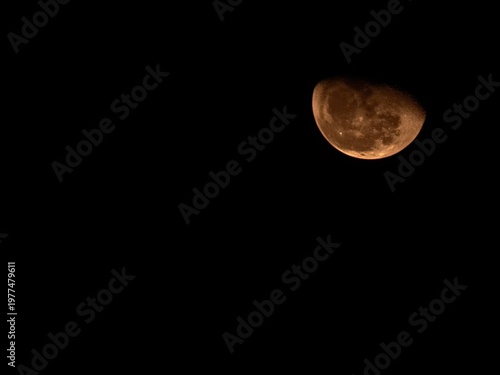 Orange Red Half Moon Against Black Night Sky