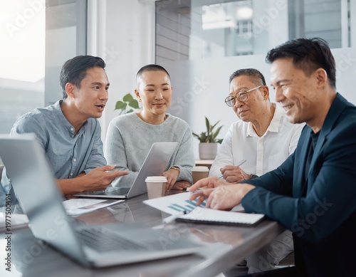 Wallpaper Mural Diverse group of individuals engaged in a meeting, with charts and laptops in front of them Torontodigital.ca
