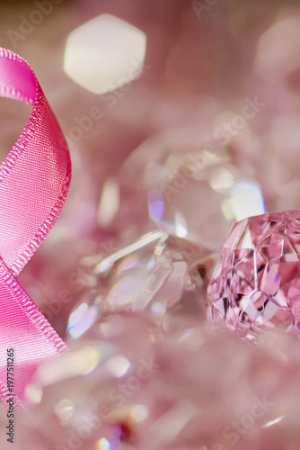 A pink ribbon rests on top of a pile of crystals, perfect for decorative or symbolic uses