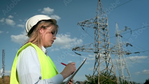 Experienced power engineer inspecting high-voltage electric lines on site