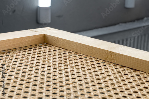 Photography Handcrafted wooden frame with natural rattan webbing inside a professional paint