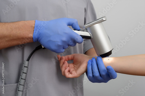Tableau sur toile Dermatologist using digital dermatoscope to examine patient's mole on arm, docto