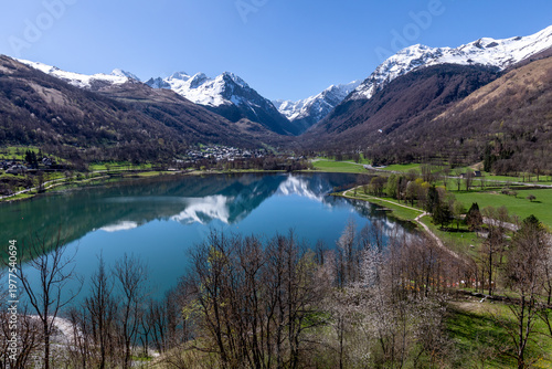 Fotografi View of Lake Génos in Genos, Midi-Pyrenees, France, with the snow-capped Pyrenee