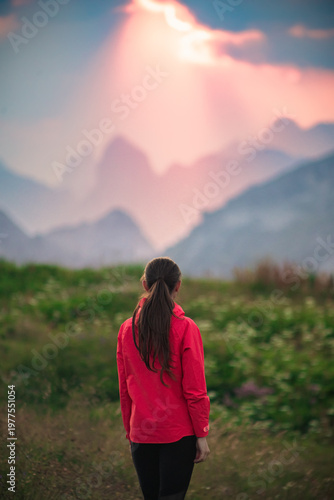 Billede på lærred Woman contemplating sunset mountain landscape in meadow