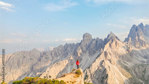 Фотография Woman enjoying freedom on mountain summit overlooking dolomites