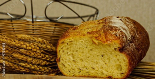 Freshly baked bread with wheat in a rustic basket