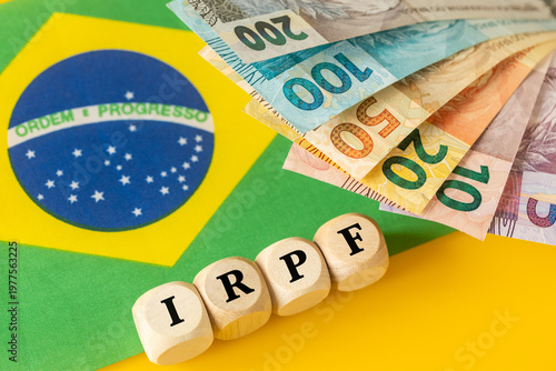 IRPF, Imposto de Renda de Pessoa Física, English translation Personal Income Tax. Financial concept. Taxes in Brazil. written on wooden blocks, Brazilian money, calculator, business background