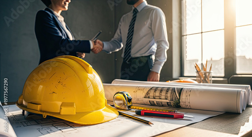 Businessmen shaking hands over construction plans.