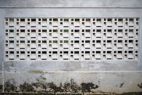Tableau sur toile White decorative breeze blocks on a weathered concrete wall, minimalist architec