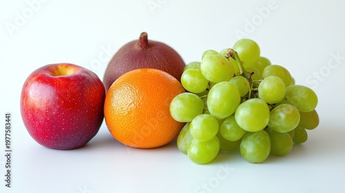 Red apple, orange, red onion, and green grapes on white background.