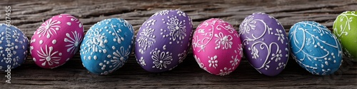 Row of colorful Easter eggs with floral patterns on rustic wooden background