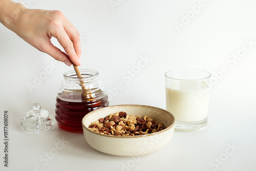 Sweet breakfast, honey dripping into a bowl of cereal flakes.