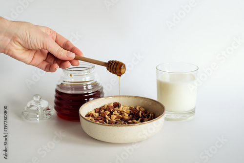 Sweet breakfast, honey dripping into a bowl of cereal flakes.