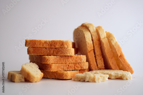 Sliced white bread and crumbs on white background.
