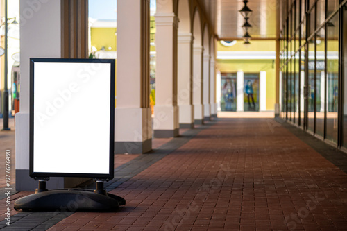 Foto Blank mockup sign in outdoor shopping area with empty storefronts and columns