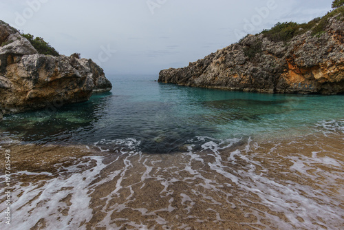 Aquarium bay with beach and rock formations on the Adriatic sea coast with turquoise colored water near Himare, Albania