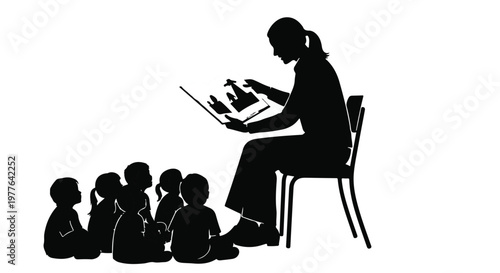 Silhouette of a woman teacher reading a book to children sitting on the floor