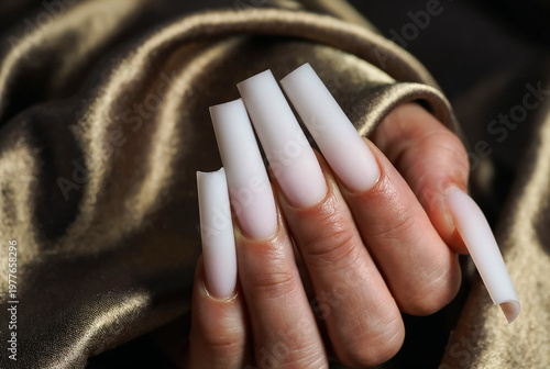 Dramatic Long Professional Acrylic Nail Extensions in Milky White Color with Square Shape Over Gold Satin Drapery