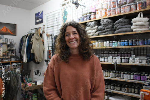 Independent shop owner and seller in one, serving a customer inside a small family-run household goods shop, casual domestic atmosphere, soft overhead light, real unpolished look