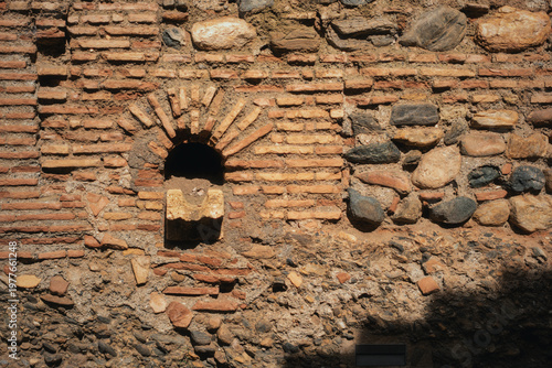 Obraz na plátne Alcazaba brick and stone wall with an arched niche, showing weathered texture fr