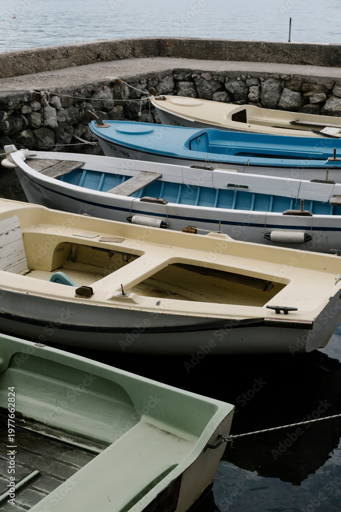 Fototapeta premium Boats, dock and water in harbor, colorful vessels moored at pier, peaceful scene of leisure and relaxation, summer day by the coast, marine lifestyle and tranquility.