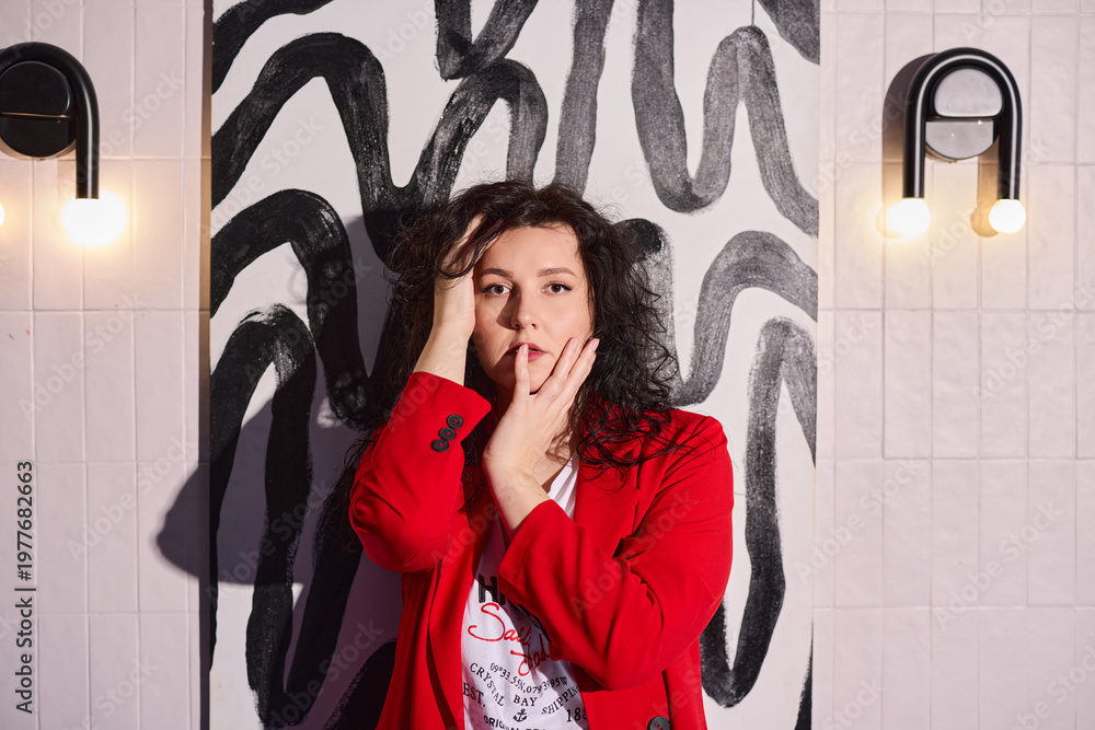 Fototapeta premium Creator dressed in striking crimson attire captured in mural setting