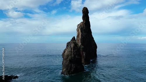 Majestic sea stacks rise from the turquoise Atlantic, framing Madeira's rugged, green coastline near Ribeira da Janela. A breathtaking natural spectacle.