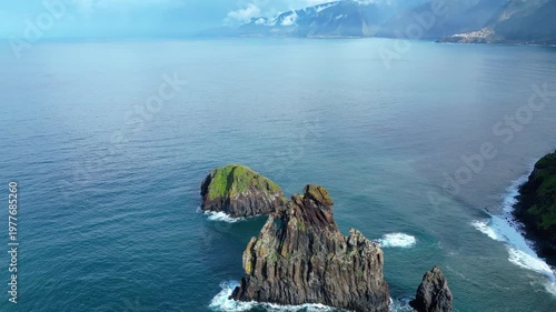 Dramatic sea stacks rise from the Atlantic off Madeira's verdant coast. A breathtaking aerial view of Ribeira da Janela's iconic natural beauty.