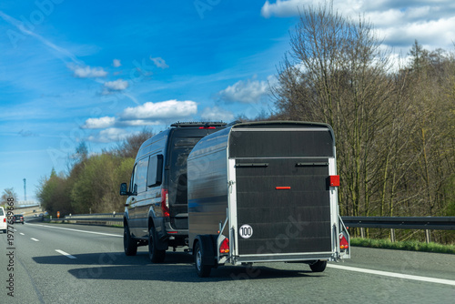 Van towing cargo trailer on highway road transportation logistics and delivery concept
