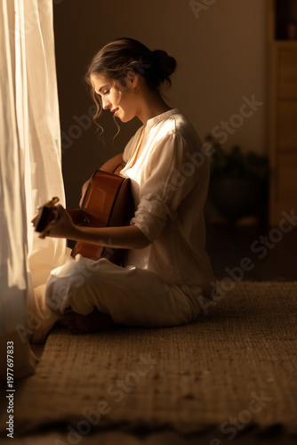 Serene woman creating melodies in a sunlit room with natural warmth