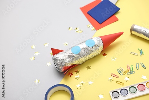 Handmade rocket and art materials on color background, closeup. Space for text