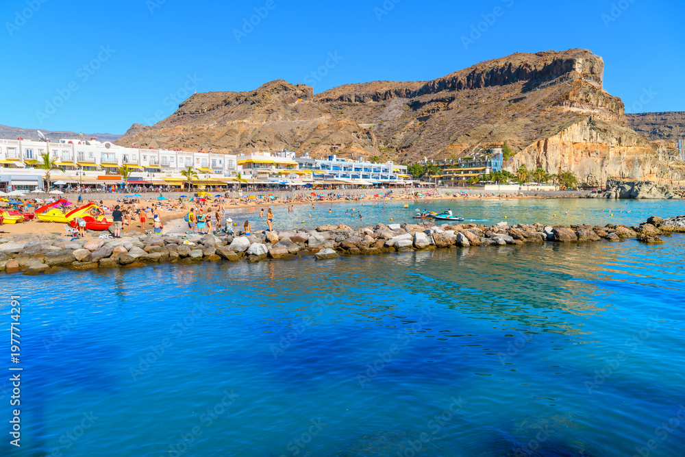 Fototapeta premium The sandy Playa de Mogán, a popular sandy beach and tourist resort in Puerto de Mogán, located on the southwestern coast of the island of Gran Canaria in Spain.