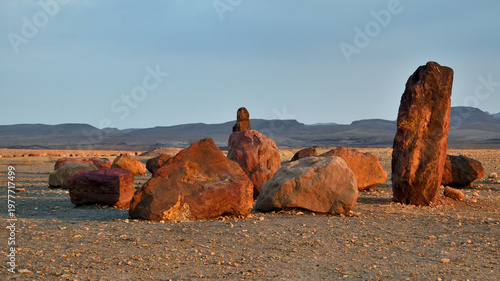 Red Iron Sandstone Boulders on Makhtesh Ramon Crater Floor at Golden Hour, Negev Desert Israel travel photo with copy space