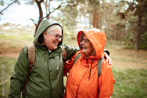Senior women friends hiking in rainy forest