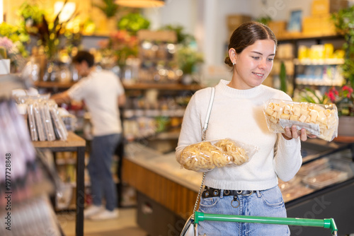 Foto Girl compare and choosing pasta, doubt and think before buying