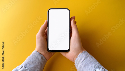 Wallpaper Mural A woman hands hold a smartphone with a blank screen against a bright yellow background. Generative AI. Torontodigital.ca