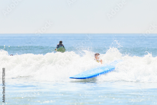 Canvastavla A surfer falls into the ocean as their blue surfboard splashes through a wave, capturing an action-packed surfing wipeout moment