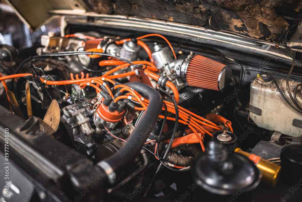 Naklejka premium Detailed view of a classic car engine with orange spark plug wires and air filter