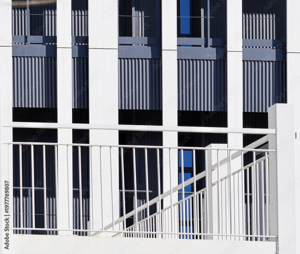 Fototapeta premium Modern Building Facade with White Railing and Vertical Elements