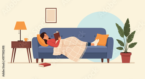 Enjoying a cozy afternoon while reading a book on a blue sofa in a living room with warm light and a plant