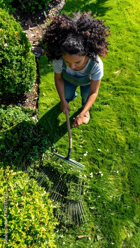 Young Woman Raking Leaves in a Lush Green Garden.