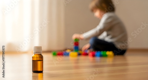 Amber medicine bottle on wooden floor with blurred child playing background.