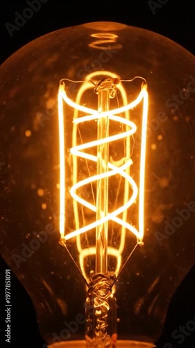 A close up view of a glowing vintage light bulb filament against a dark background