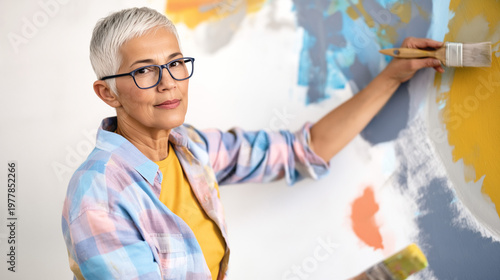 Elderly Woman Painter Creating Colorful Modern Art for Home Decor: A DIY Project with Vibrant Brush Strokes