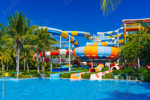 water park in the pool at resort on summer vacation. Colorful aquapark with slides