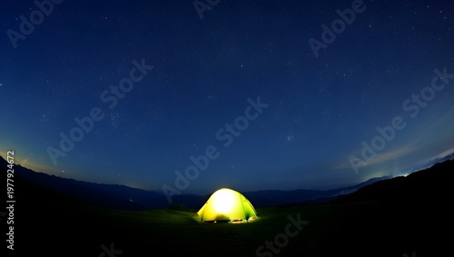 Nighttime mountain view featuring illuminated tent under starry sky with long exposure effect