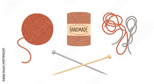 Handmade craft supplies including a ball of rust colored yarn a spool labeled 'handmade' tangled threads and crossed