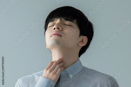 Korean man with neck pain. Concept of sore throat, pharyngitis, laryngitis, thyroiditis, choking