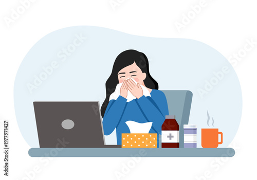 Woman suffering from a cold or flu sits at her desk, blowing her nose into a tissue while attempting to work from home.
