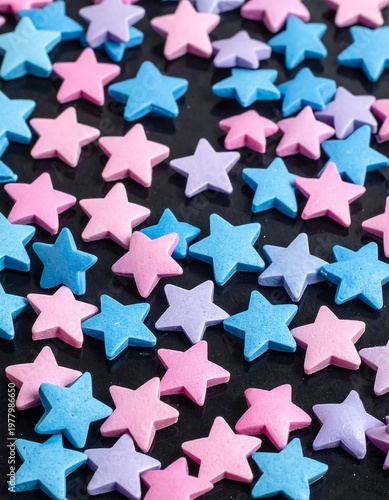 A scattered assortment of colorful star-shaped objects on a dark surface